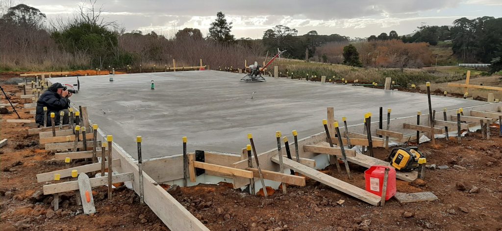 Concrete slab construction site with surrounding formwork.