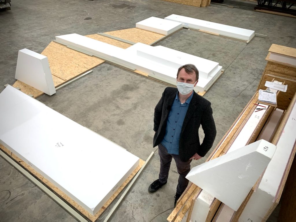 Person stands near large foam blocks in warehouse.